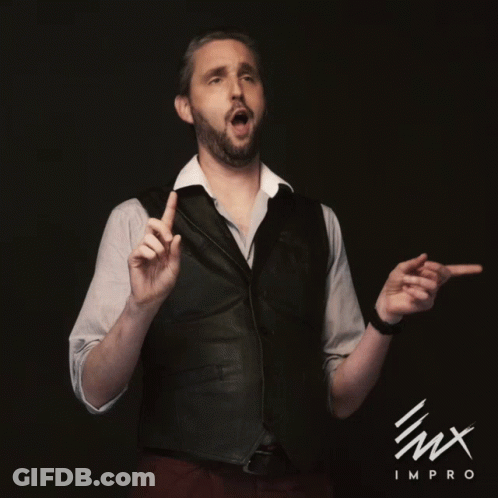 A Man Wearing A Vest And A White Shirt Stands In Front Of A Black Background That Says Lmx Improv GIF