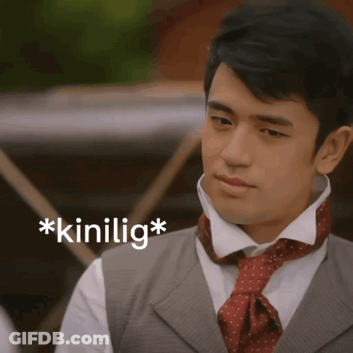 A Man Wearing A Vest And Tie Has The Word * Kinilig * On The Bottom Right GIF