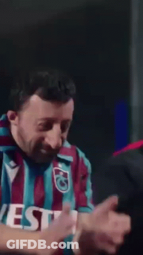 A Man Wearing A Vest Shirt Is Making A Funny Face . GIF