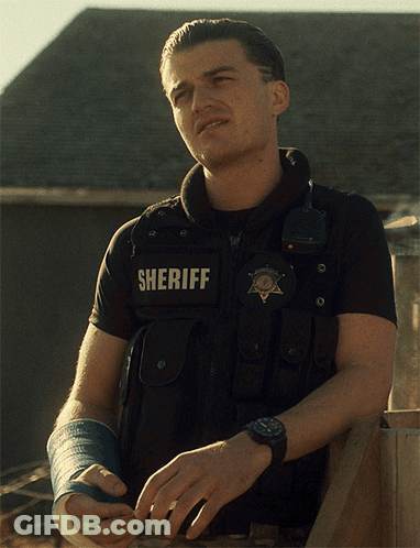 A Man Wearing A Vest That Says Sheriff On The Back GIF
