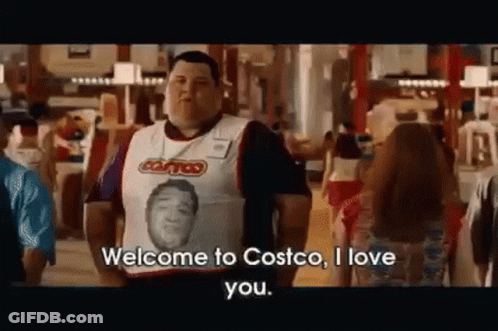 A Man Wearing A Vest With A Picture Of A Man On It Is Standing In Front Of A Crowd In A Store . GIF