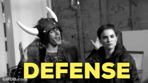 A Man Wearing A Viking Helmet Stands Next To A Woman With The Word Defense In Yellow GIF