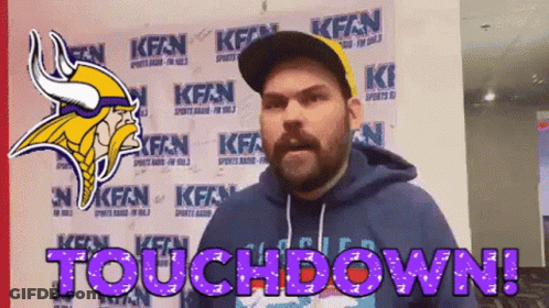 A Man Wearing A Vikings Helmet Is Standing In Front Of A Wall That Says Touchdown GIF