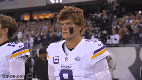 A Man Wearing A Vikings Uniform Stands On The Field GIF