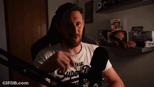 A Man Wearing A Vintage Super Dry T-Shirt Stands In Front Of A Microphone GIF