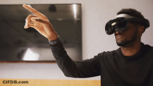 A Man Wearing A Virtual Reality Headset Is Pointing To Something GIF
