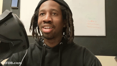 A Man Wearing A Virtual Reality Headset Is Smiling In Front Of A White Board That Says New Plan GIF