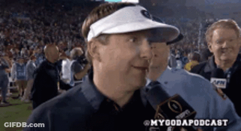 A Man Wearing A Visor Is Talking Into A Microphone . GIF