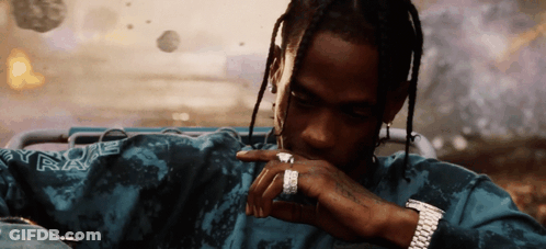A Man Wearing A Watch And A Ring Is Wearing A Shirt That Says Travis Scott GIF