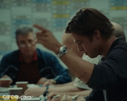 A Man Wearing A Watch Is Sitting At A Table With Other Men GIF