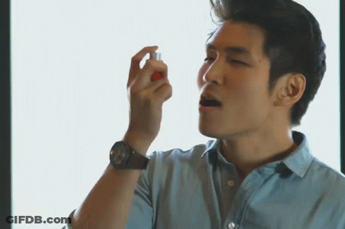 A Man Wearing A Watch Is Spraying Something In His Hand GIF