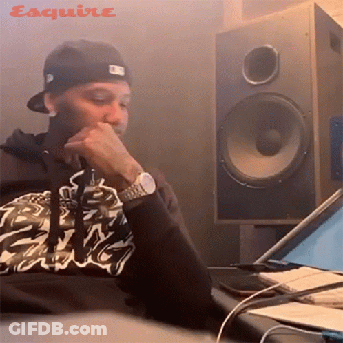 A Man Wearing A Watch Sits In Front Of A Speaker With The Word Esquire On It GIF