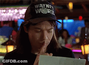 A Man Wearing A Wayne World Hat Holds His Finger To His Mouth GIF