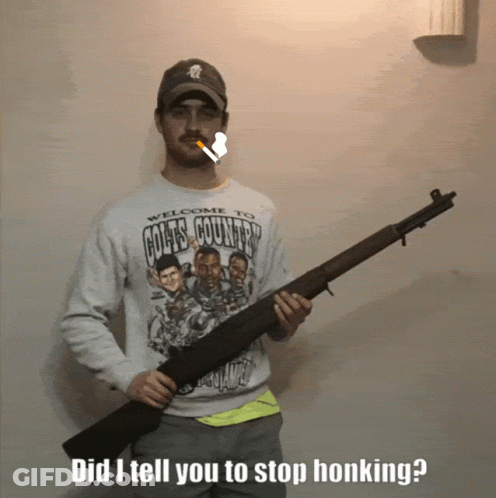 A Man Wearing A Welcome To Goats Country Sweatshirt Holds A Shotgun GIF