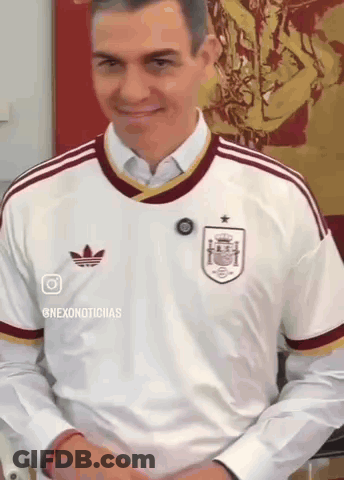 A Man Wearing A White Adidas Shirt Is Smiling And Looking Down GIF