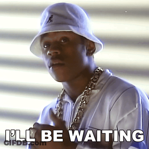 A Man Wearing A White Bucket Hat And A Gold Chain Says I 'Ll Be Waiting GIF