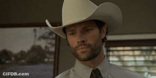 A Man Wearing A White Cowboy Hat And Tie GIF