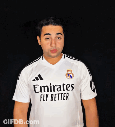 A Man Wearing A White Emirates Fly Better Jersey Blows A Kiss GIF