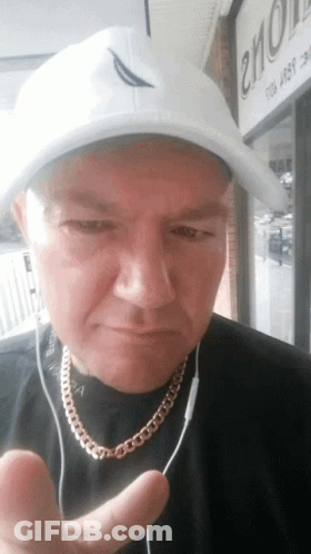 A Man Wearing A White Hat And A Gold Chain Is Giving The Thumbs Up Sign GIF