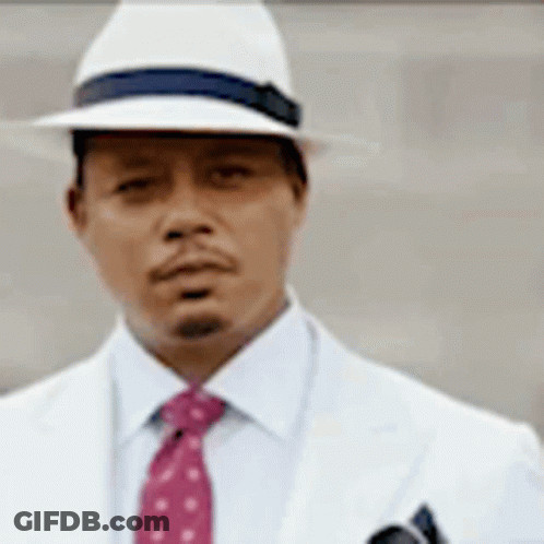A Man Wearing A White Hat And A Red Tie Is Standing In Front Of A Wall . GIF