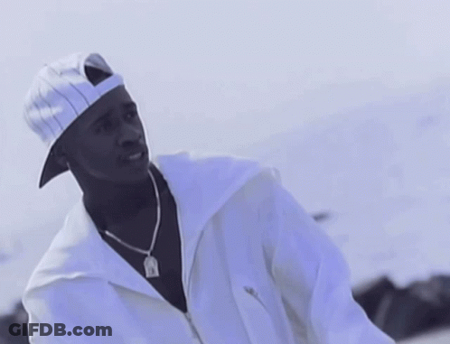 A Man Wearing A White Hat And A White Jacket Has A Pendant Around His Neck That Says Jesus GIF
