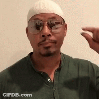 A Man Wearing A White Hat And Sunglasses Is Holding A Small Object In His Hand . GIF
