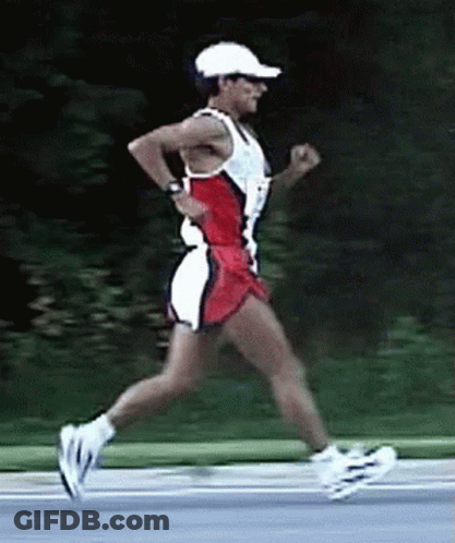 A Man Wearing A White Hat And Sunglasses Is Running On A Road GIF