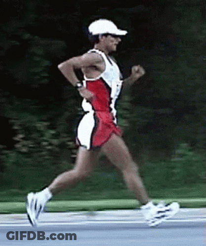 A Man Wearing A White Hat And Sunglasses Is Running On A Road GIF