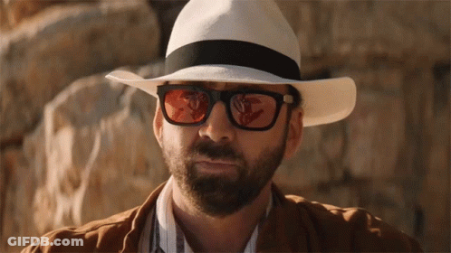 A Man Wearing A White Hat And Sunglasses Looks At The Camera GIF