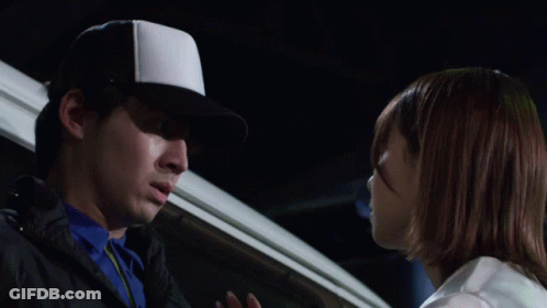 A Man Wearing A White Hat Is Touching Another Man 'S Face GIF