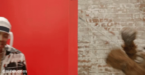 A Man Wearing A White Headband Is Standing In Front Of A Brick Wall GIF