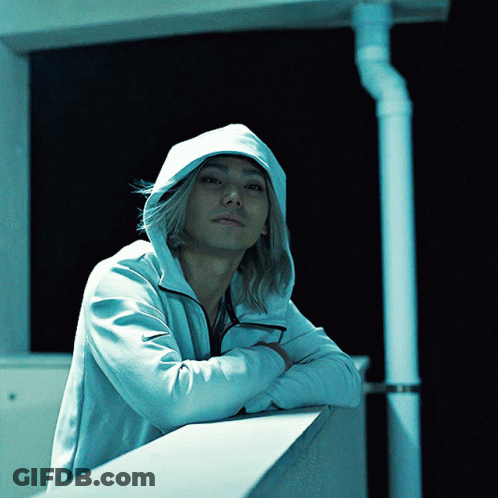 A Man Wearing A White Hoodie Is Leaning On A Railing With His Arms Crossed GIF