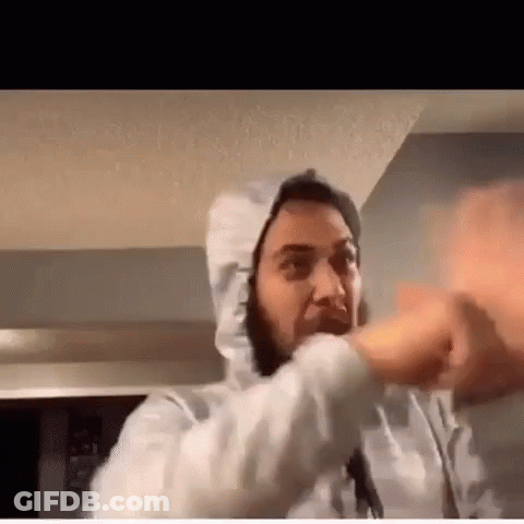 A Man Wearing A White Hoodie Is Making A Funny Face While Talking On A Video Call . GIF