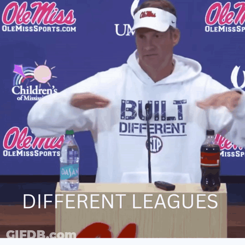 A Man Wearing A White Hoodie That Says " Built Different " GIF