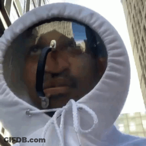 A Man Wearing A White Hoodie With A Reflection Of A Building In It GIF