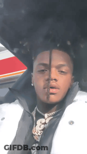 A Man Wearing A White Jacket And A Black Shirt With The Number 33 On It GIF