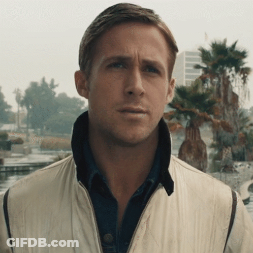 A Man Wearing A White Jacket And A Blue Shirt Looks At The Camera GIF