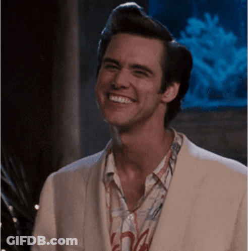 A Man Wearing A White Jacket And A Shirt With The Letter A On It Smiles GIF