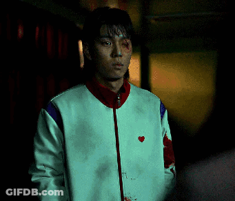 A Man Wearing A White Jacket With A Red Heart On It GIF