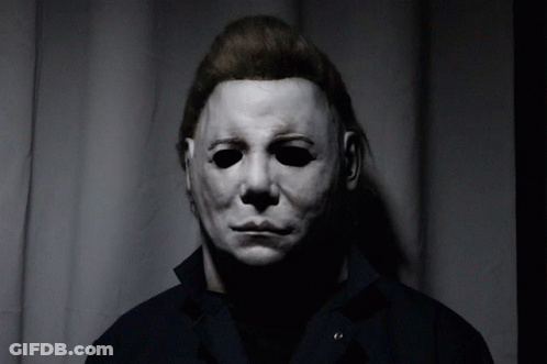 A Man Wearing A White Mask And A Black Jacket GIF