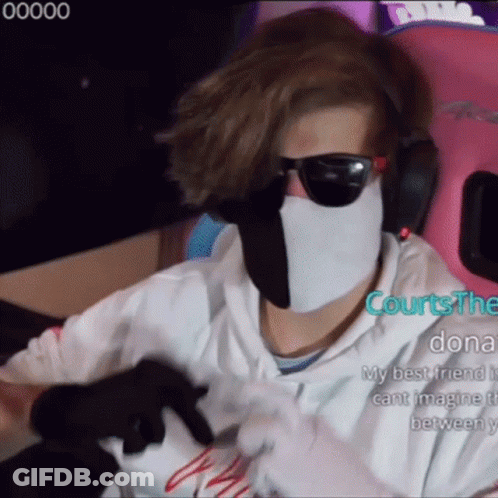 A Man Wearing A White Mask And Sunglasses Is Sitting In A Pink Chair . GIF