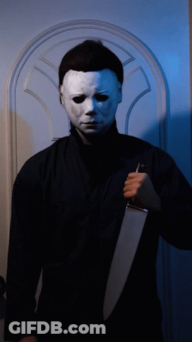 A Man Wearing A White Mask Holds A Gun GIF