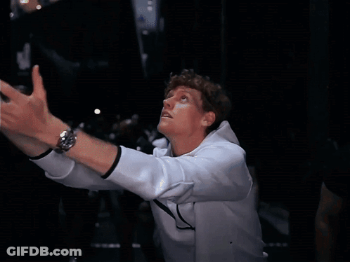 A Man Wearing A White Nike Jacket Holds A Tennis Ball In His Hand GIF