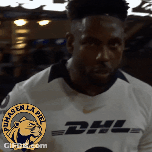 A Man Wearing A White Pumas Jersey With Dhl On The Front GIF