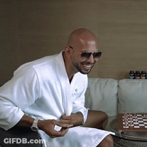 A Man Wearing A White Robe And Sunglasses Is Sitting On A Couch GIF