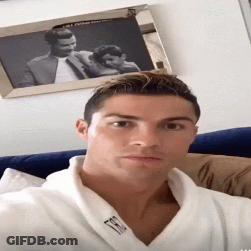 A Man Wearing A White Robe With The Letter T On The Front GIF