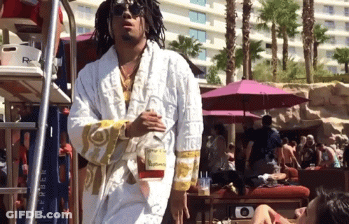 A Man Wearing A White Robe With The Word Versace On The Sleeves GIF