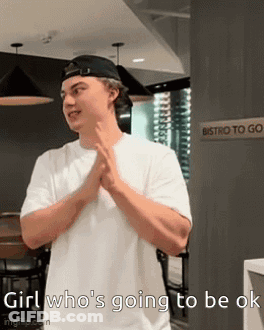 A Man Wearing A White Shirt And A Black Hat Is Standing In Front Of A Sign That Says Bistro To Go . GIF
