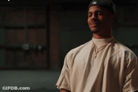 A Man Wearing A White Shirt And A Black Hat With A Ny Logo On It GIF