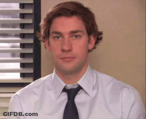A Man Wearing A White Shirt And A Blue Tie Looks At The Camera GIF